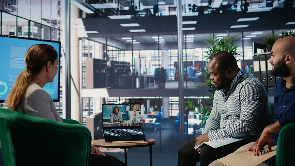 Multiethnic business leaders engaged in a web video conference in office lobby exchanging strategy