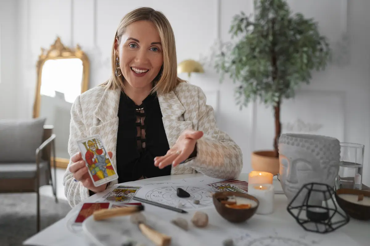 Medium shot woman reading tarot at home