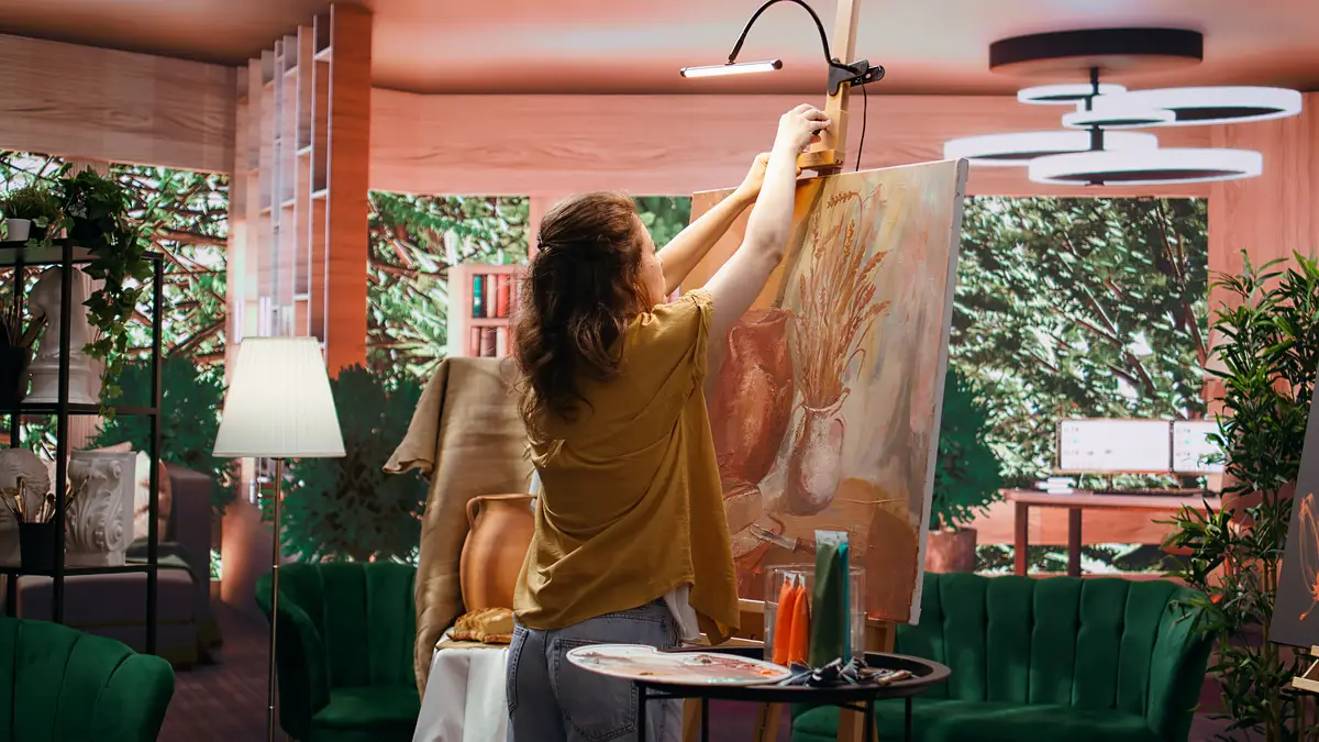Female painter using watercolor paint and mixing colors for artistic creation