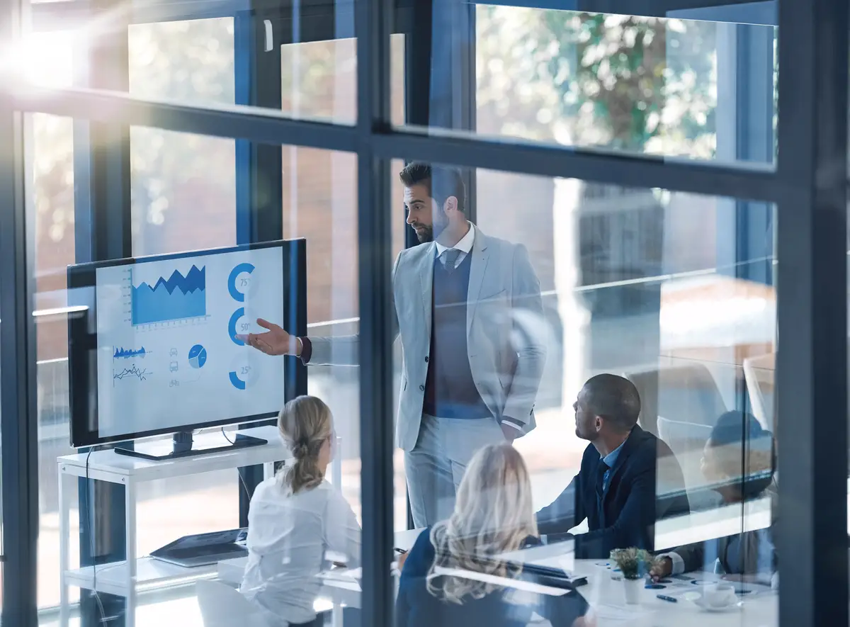 These stats look very interesting Shot of a businessman presenting information on a monitor to businesspeople in the boardroom