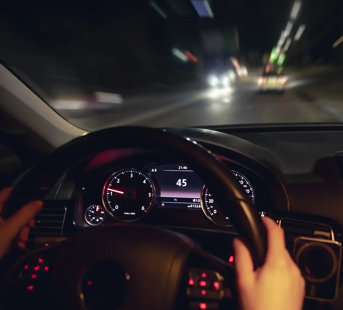 Car steering wheel and view of the night road from the car closeup