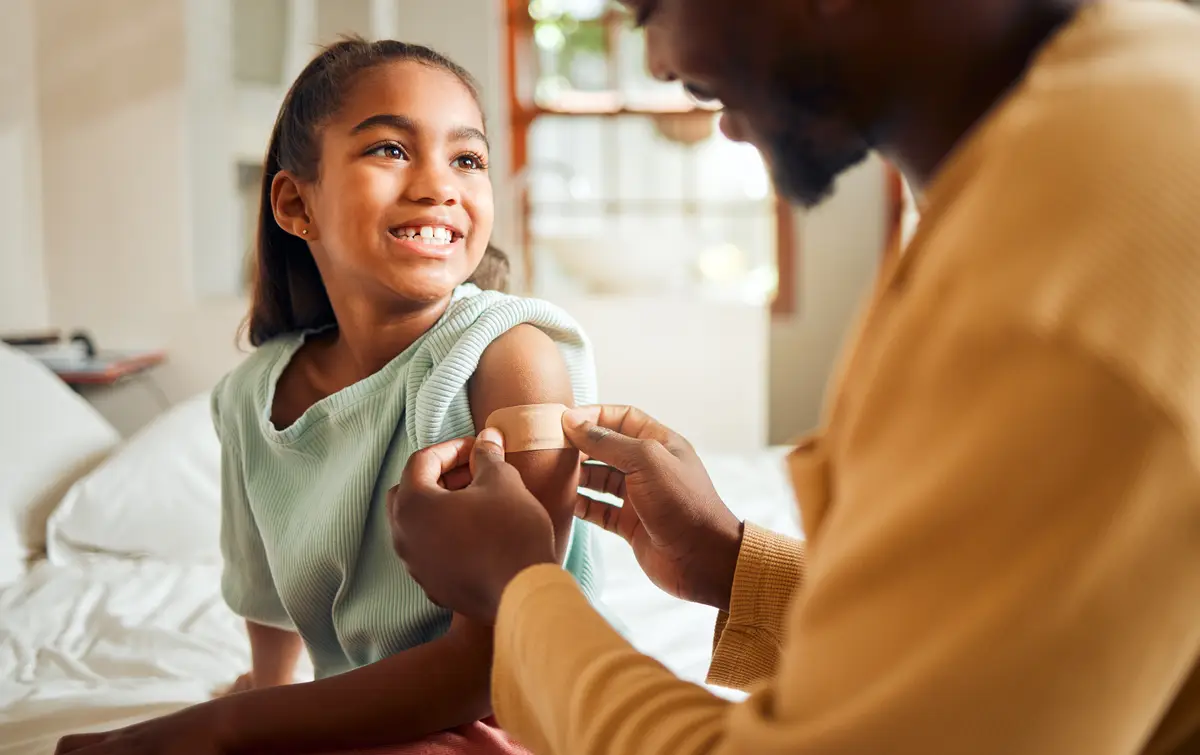 Profilaxia de infecções oportunistas em pessoas vivendo com HIV 4 Injury father and arm bandage for girl after accident in bedroom First aid black family and man apply bandaid or plaster on wound of hurt or injured child for wellness recovery and healthcare