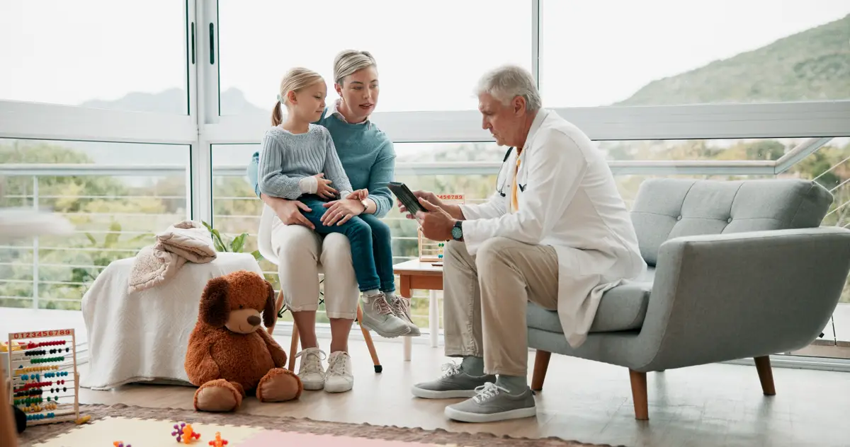 Child mom and home consultation with doctor for care health and advice in living room Senior male pediatrician kid and mother in lounge for assistance house call and appointment for wellbeing