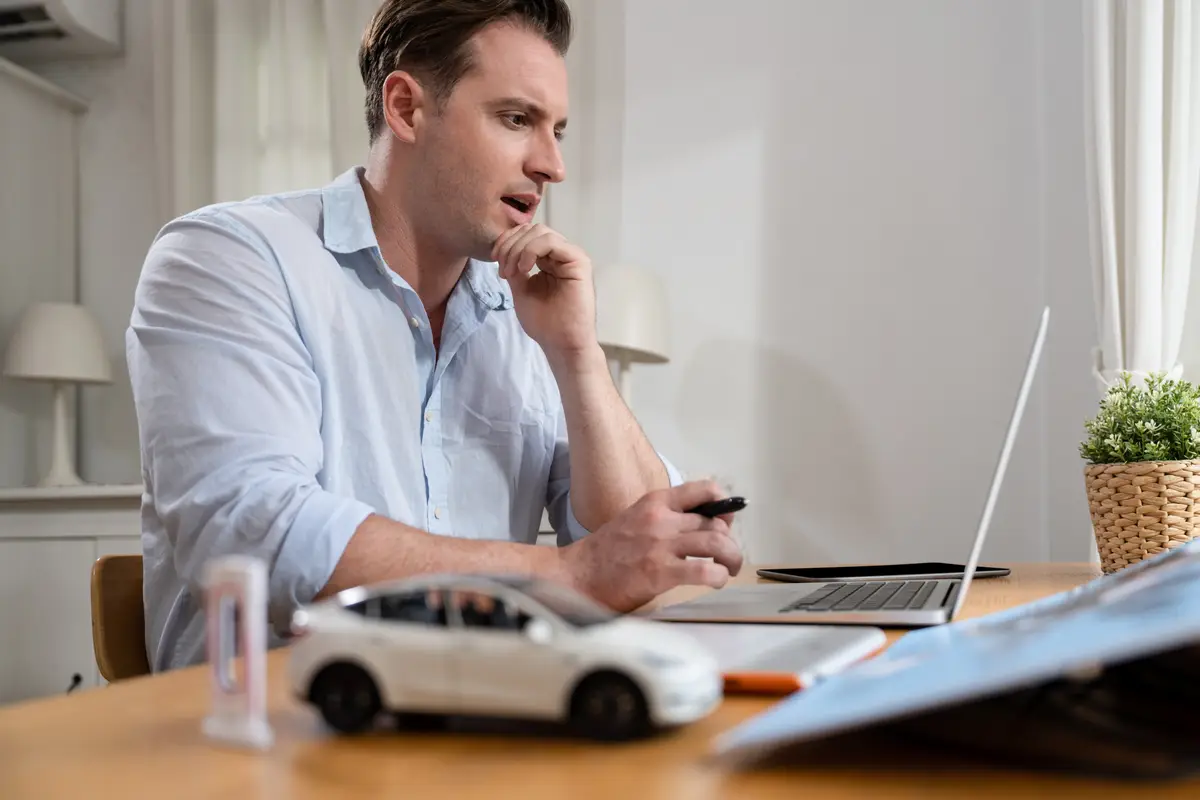 Car design engineer analyze car prototype for automobile business at home office Automotive engineering designer carefully analyze finding flaws and improvement for car design with laptop Synchronos