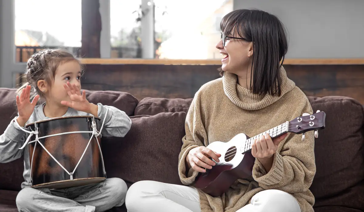 Mom plays with her daughter at home. Lessons on a musical instrument. Children's development and family values. The concept of children's friendship and family.