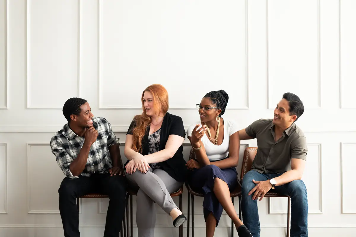 Diverse group of people men and women sitting and talking Diverse group engaging in conversation Group of friends diverse and talking together Sitting in a row waiting for job interview