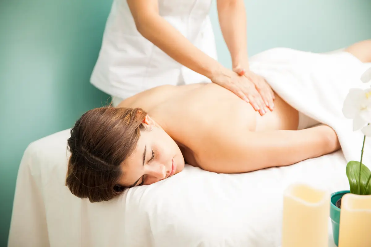 Attractive young Hispanic woman getting a back massage from a female therapist at a spa