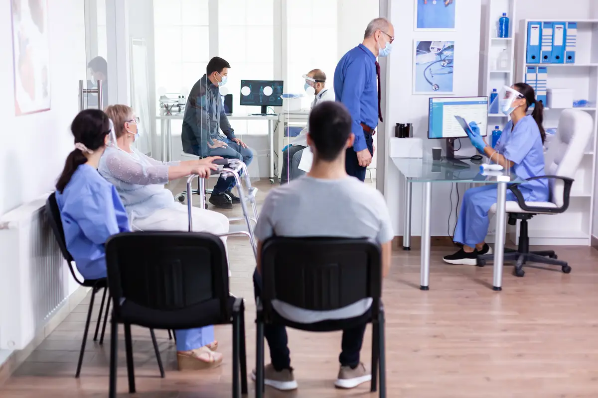 Como fortalecer programas contra IRAS em 2026 nos estados e municípios 2 Disabled senior woman with walking frame sitting in hospital waiting area for medical consultation against infection with coronavirus
