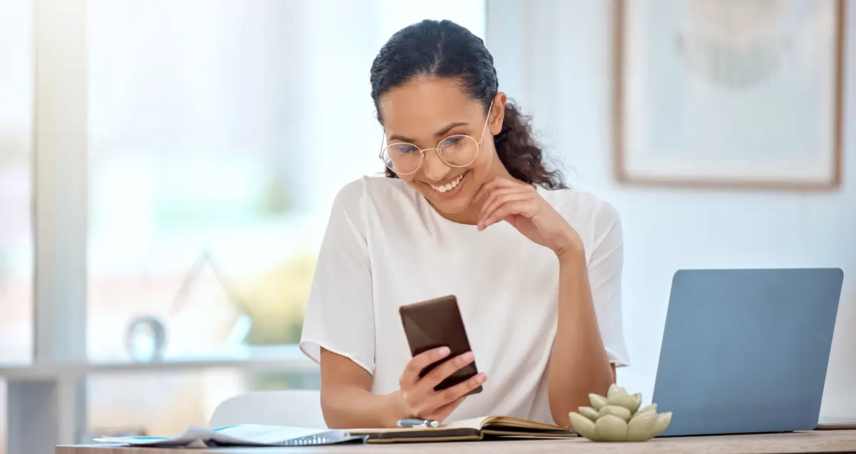 Business typing and woman with smartphone smile and connection for social media internet and digital app for news Happy person journalist and editor with cellphone online reading and research