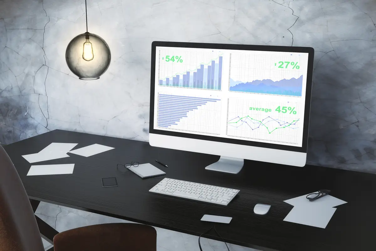 Computer with business graph on the desktop and the vintage light bulb