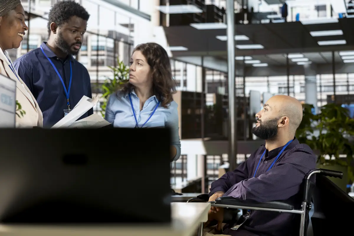 Administrator with impairment meeting with his diverse employees group