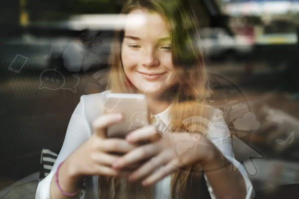 Young blond girl texting in a cafe