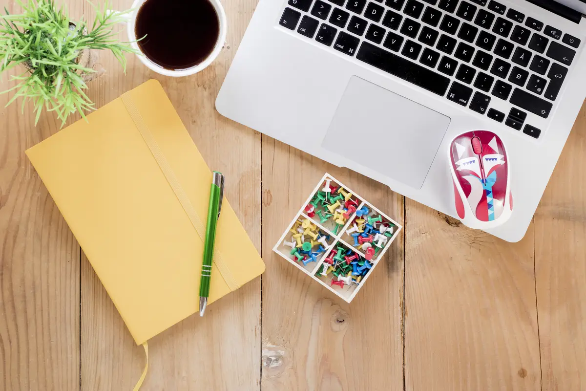 Office supplies near laptop and hot beverage