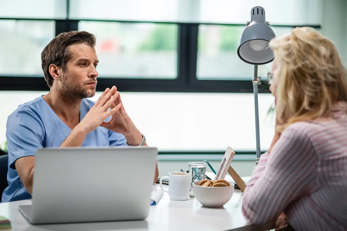 Focused healthcare worker having consultations with female patient and listening about her health issues