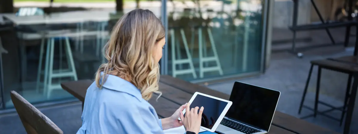 Portrait of businesswoman working on digital tablet checking diagrams sitting outdoors on fresh air