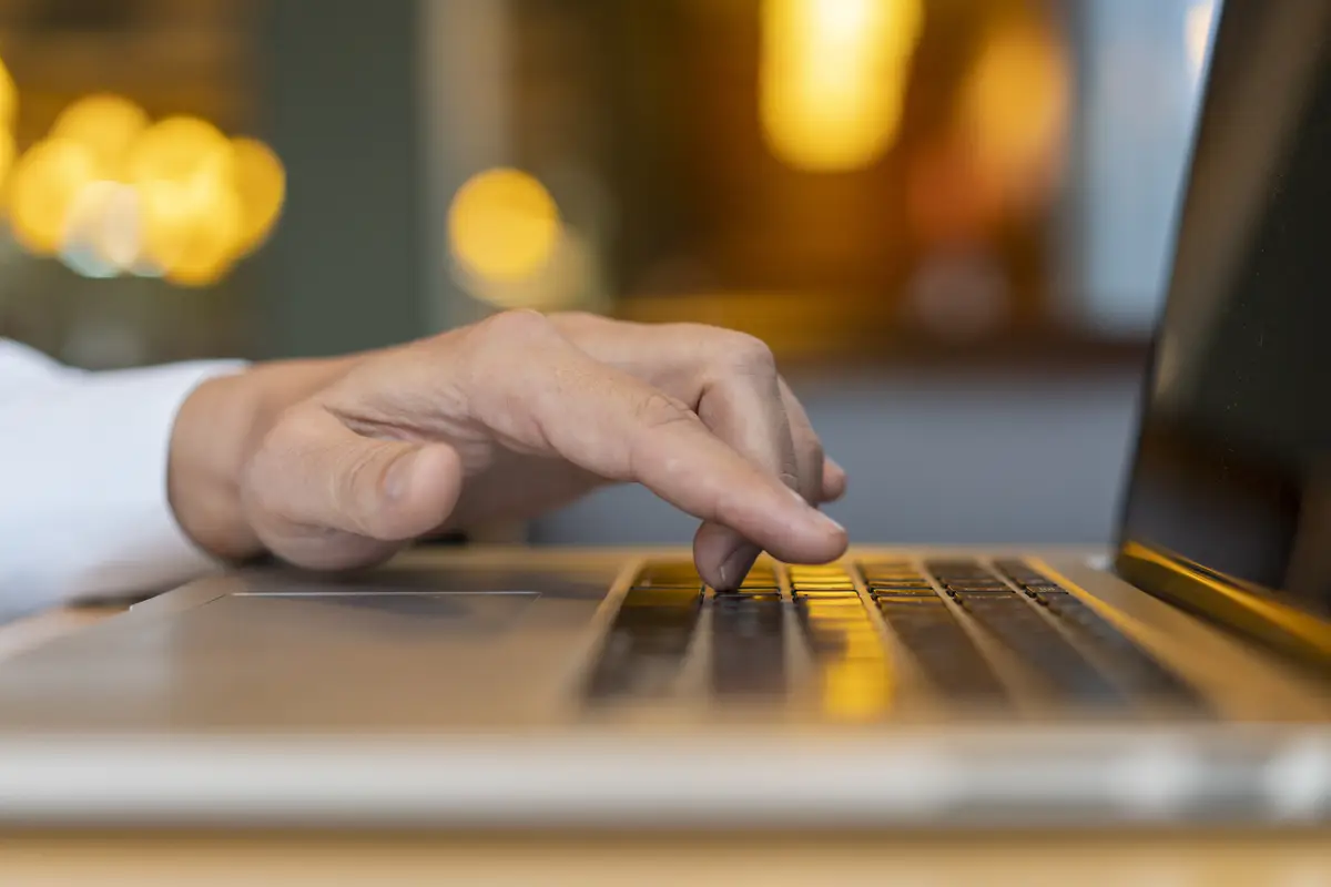 Man typing on laptop with bokeh