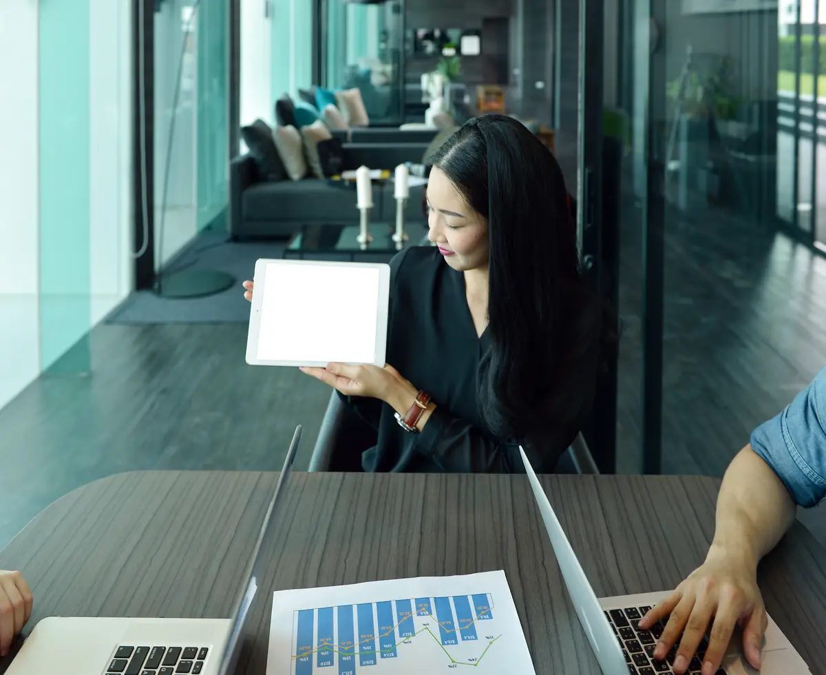 Businesswoman with colleague holding digital tablet in office