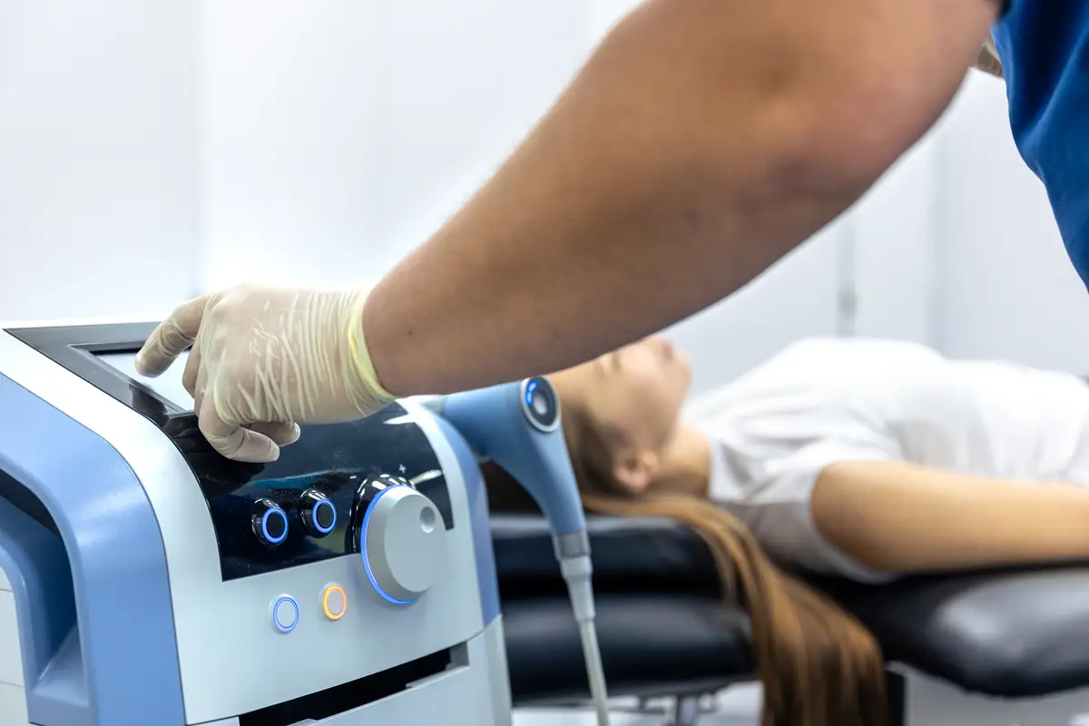 Physiotherapist adjusts rehab machine with female patient resting therapy setup moment