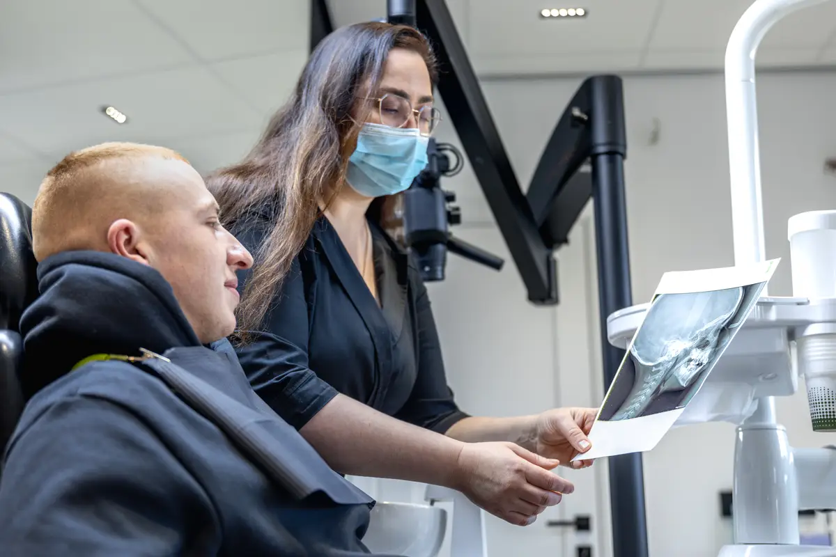 Young female dentist showing a patient a dental xray Dentistry concept