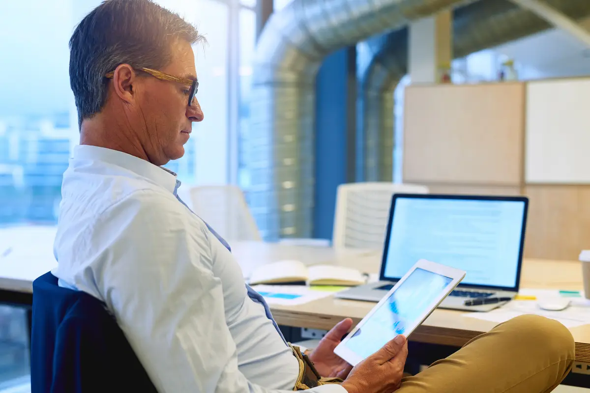 Multitasking with wireless efficiency Shot of a focussed businessman using his tablet while sitting at his desk in the office