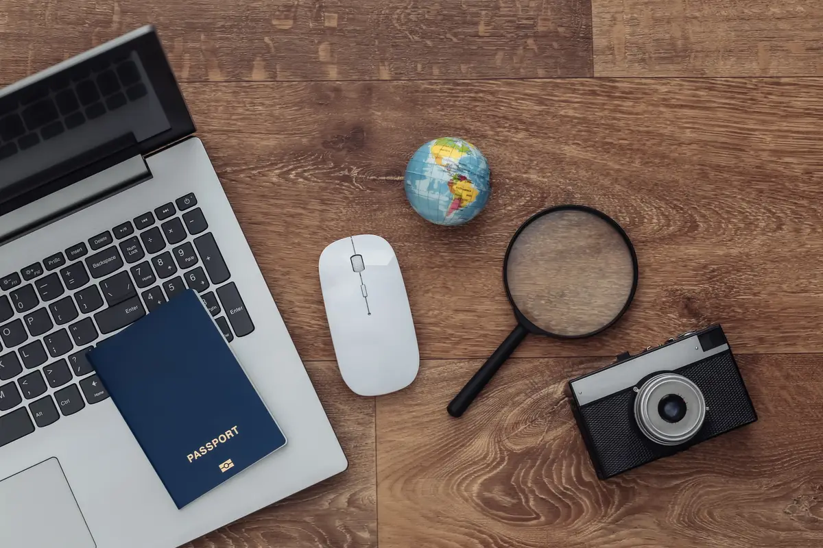 Flat lay composition of laptop and travel accessories on a wooden floor. Tourism. Top view.