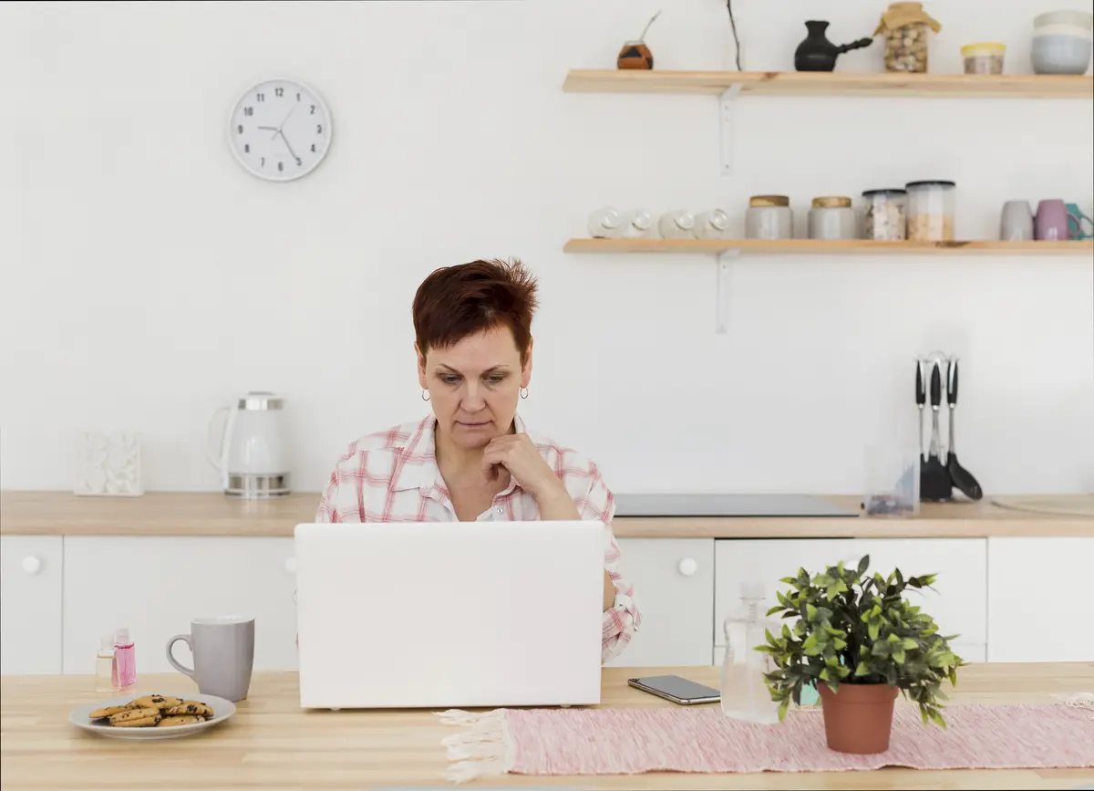 Front view of elder woman at home on her laptop