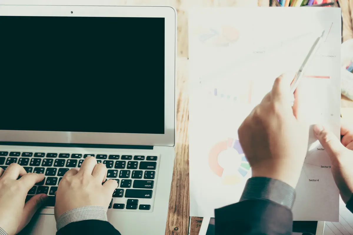 People working with a laptop and some papers