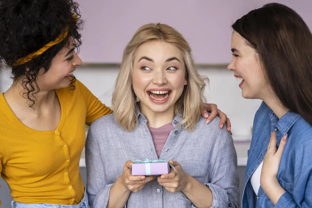 Three smiley happy women giving each other gifts