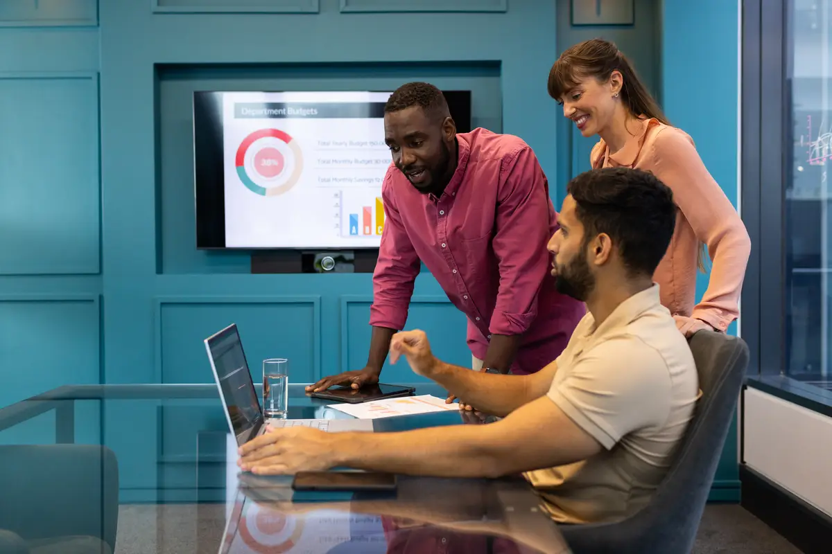 Business team discussing project using laptop and presentation in modern office