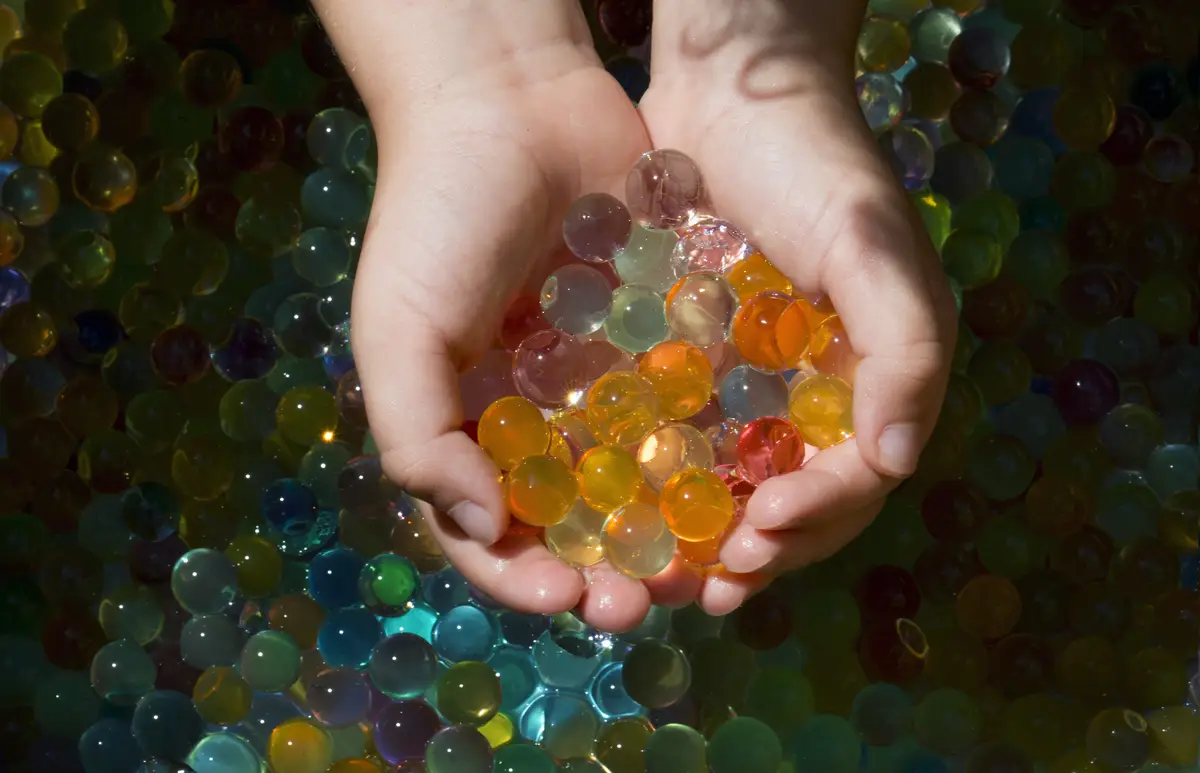 Closeup shot of multiple colored balls orbis in the small hands of a child