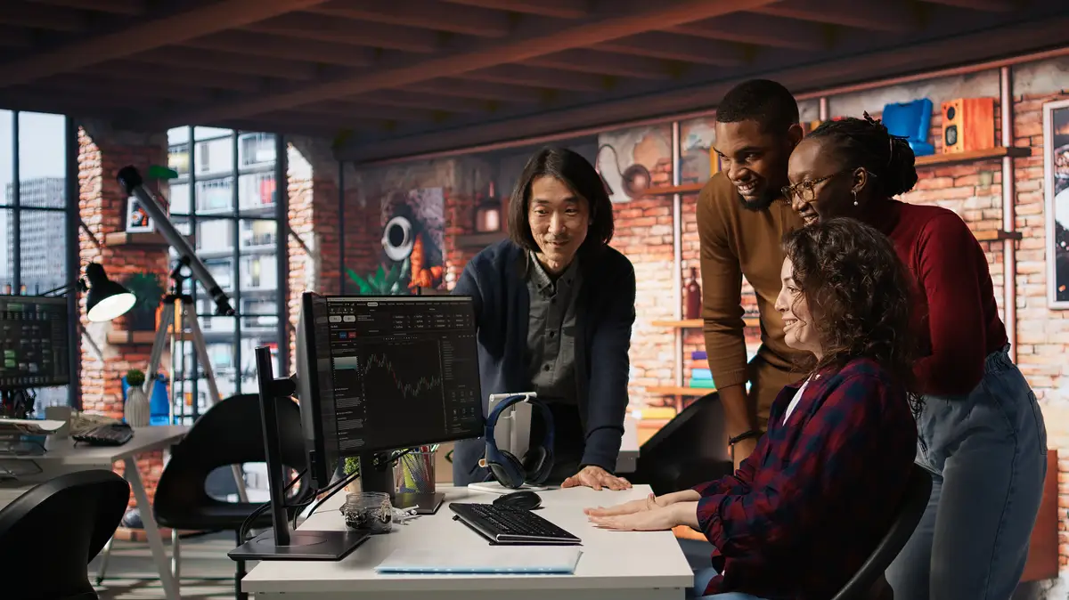 Startup team cheering after seeing company stocks raising doing high five
