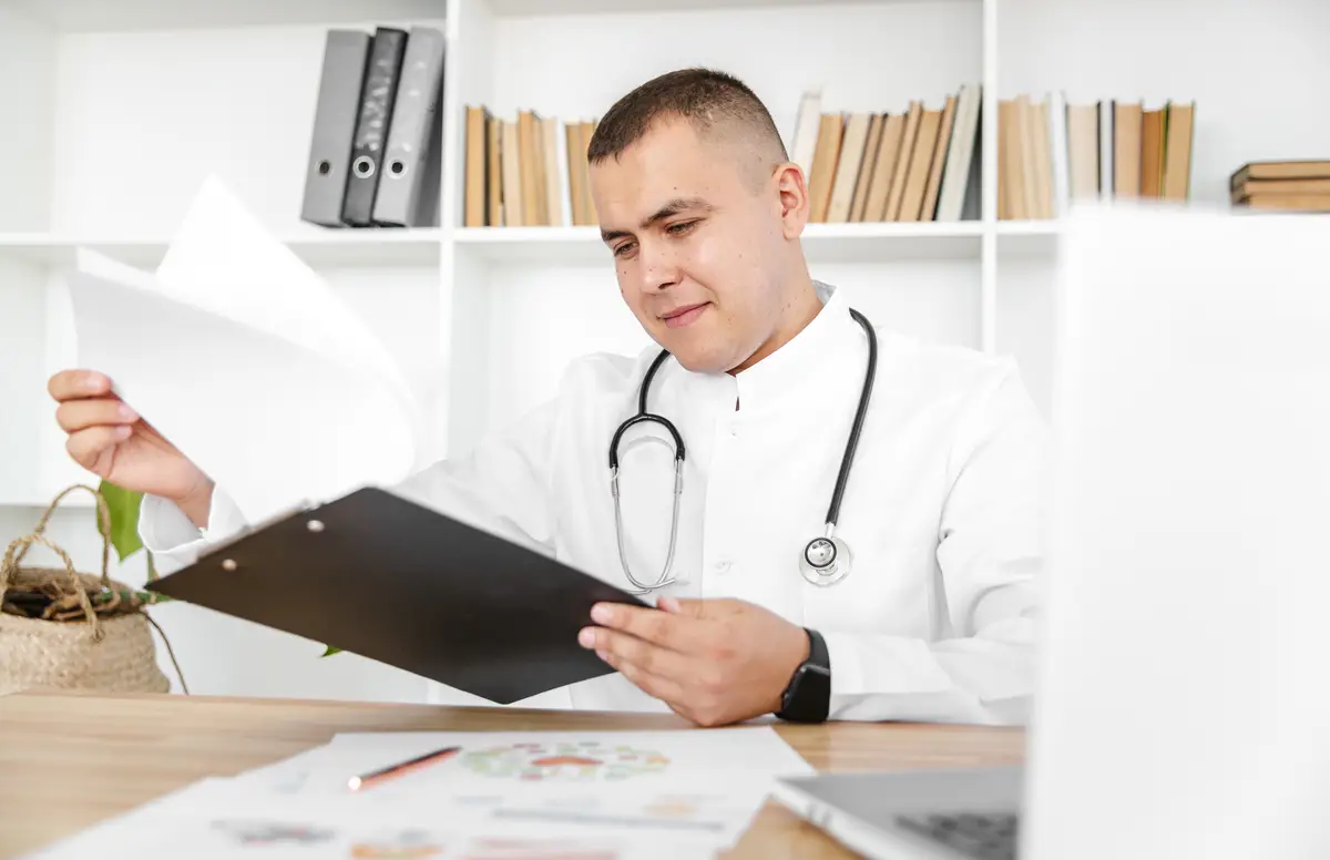 Handsome doctor holding a clipboard