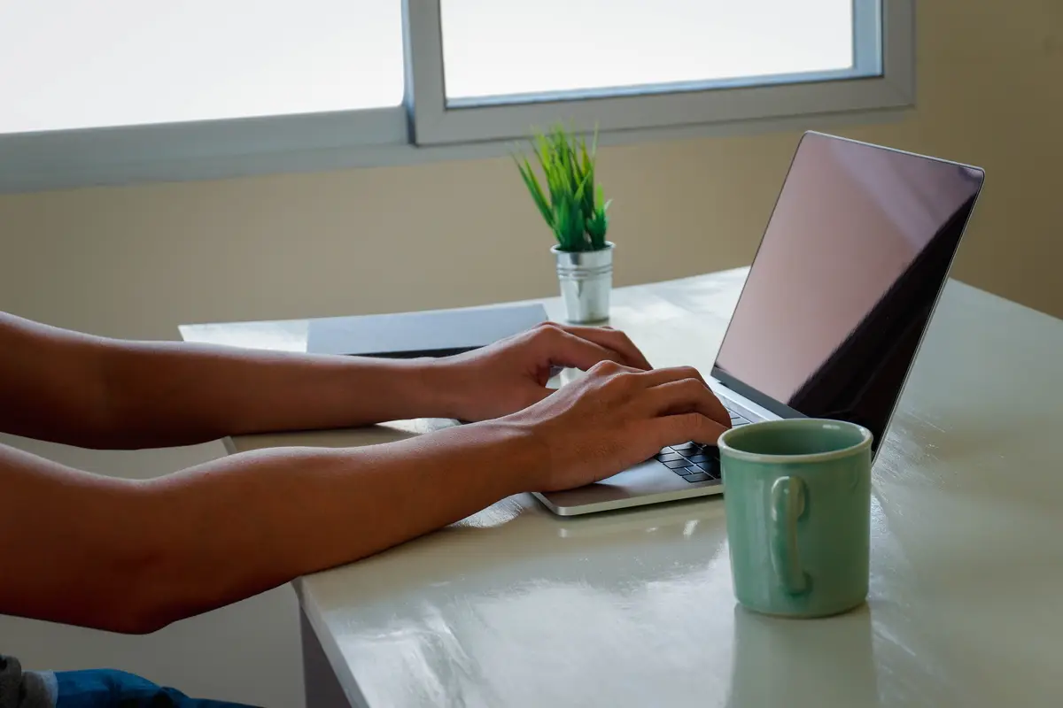 Midsection of woman using laptop on table