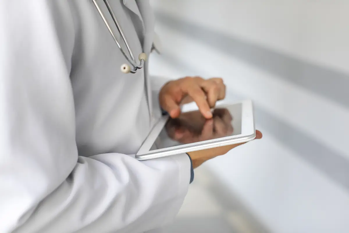 Transição para terapia oral em infecções por gram-positivos 3 Doctor hands using a modern tablet