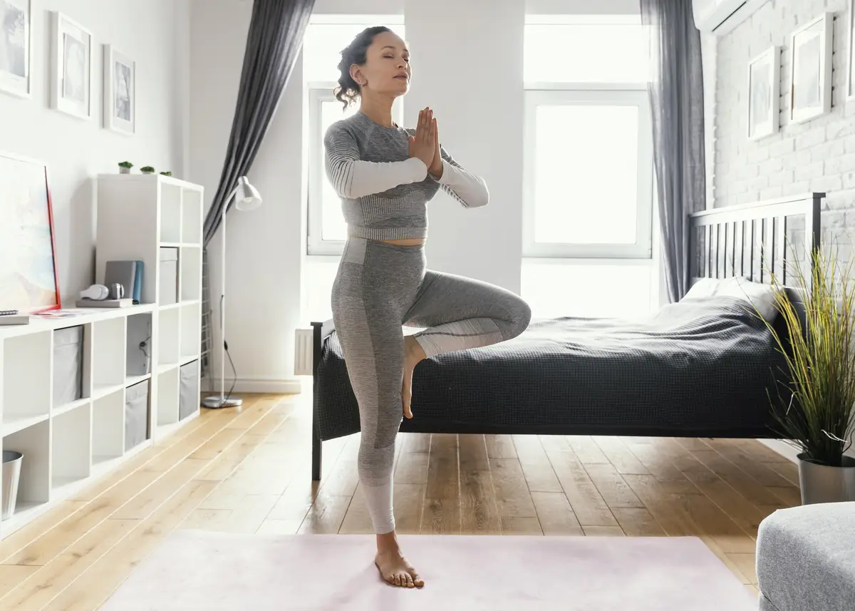 Full shot woman standing on one leg