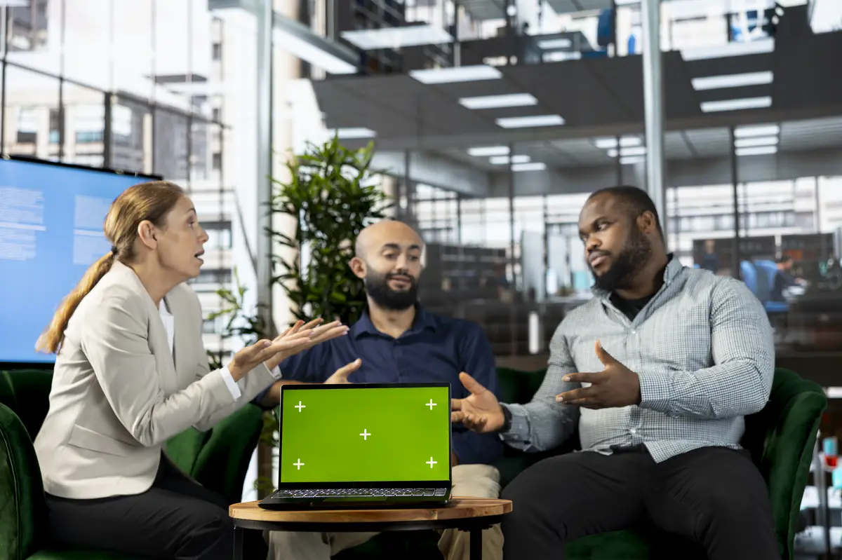 Isolated screen tablet next to workers looking over research documentation