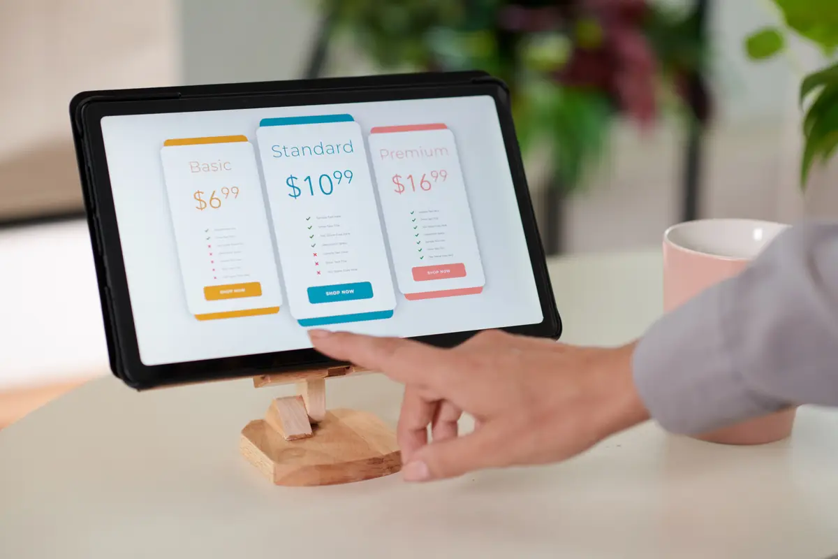 Hand of young female customer pointing at model of smartphone on tablet screen