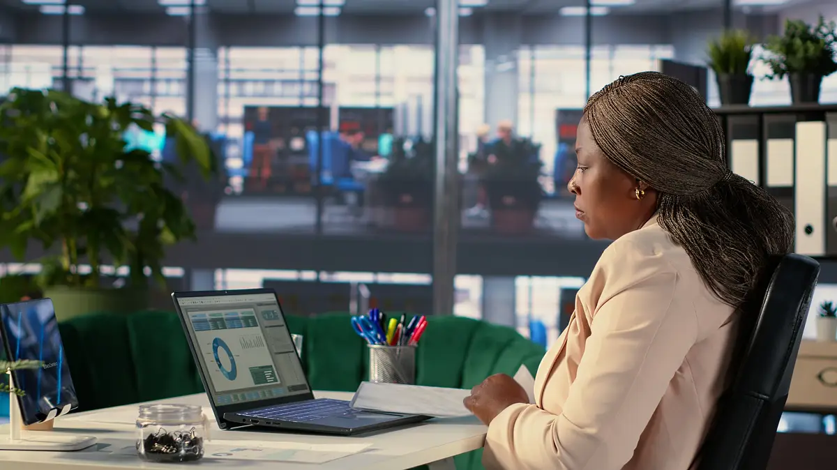 African american confident CEO working in corporate office with data analysis