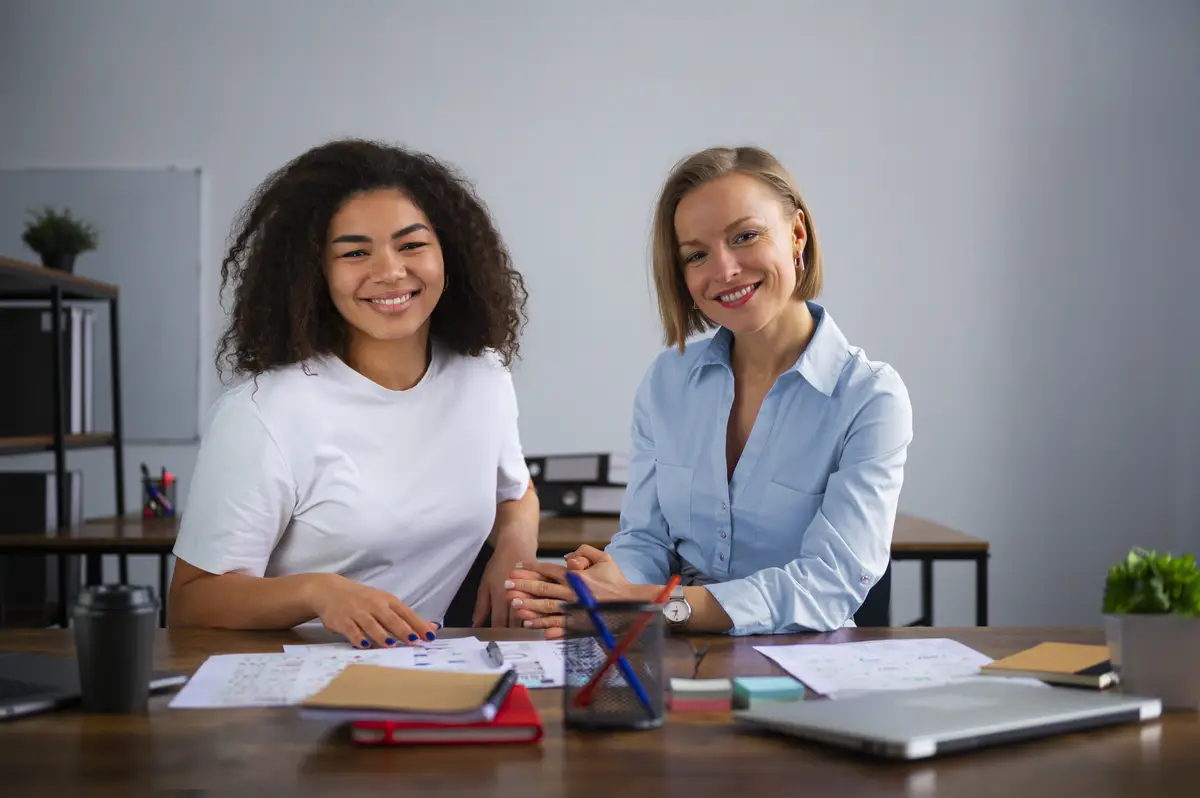 Women working together at office front view