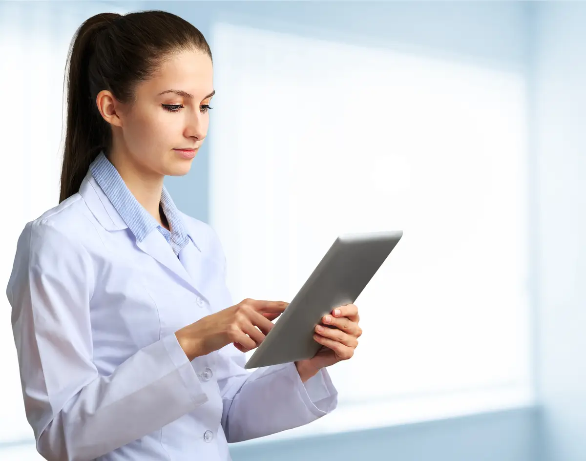 Woman doctor using tablet computer in hospital