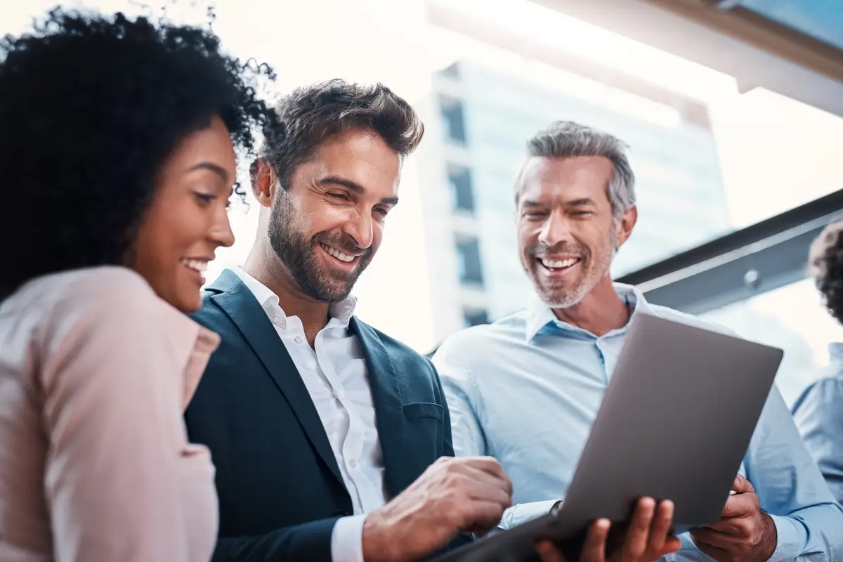 Business people laptop and laughing for research in collaboration for funny website review or reading project feedback Marketing team employees or tech for b2b networking or planning ideas at work