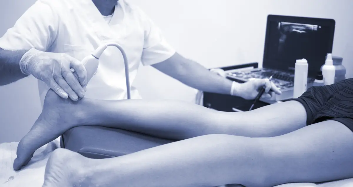 Midsection of doctor holding monitoring equipment and syringe on patient