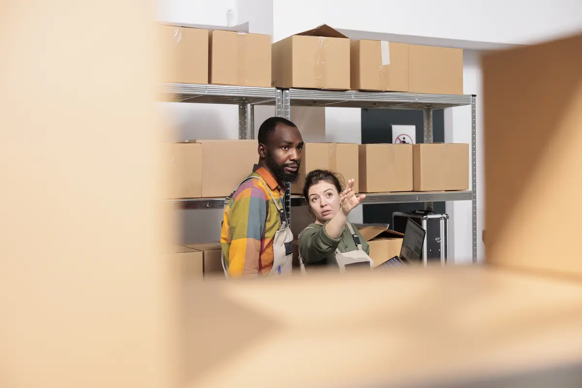 Diverse warehouse managers packing parcels