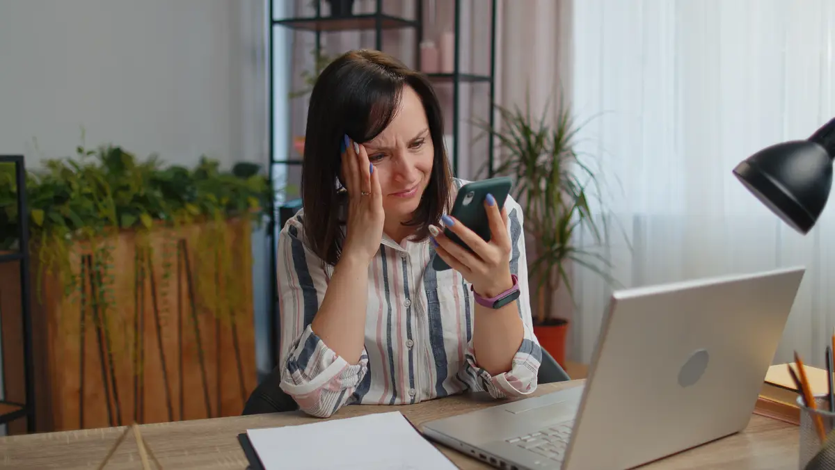 Young woman using mobile phone while sitting on table