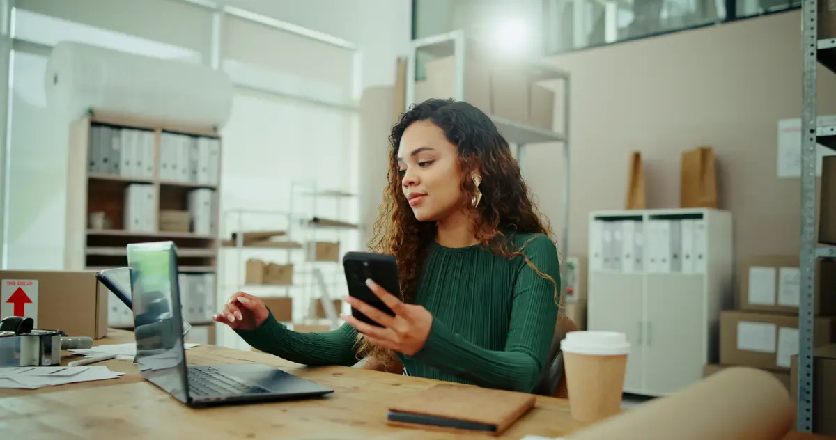 E commerce review and woman on smartphone for shipping distribution and small business courier service Delivery quality control and worker with laptop for online shopping supply chain or order