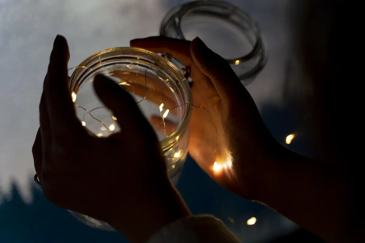 View of hands holding jar of lights