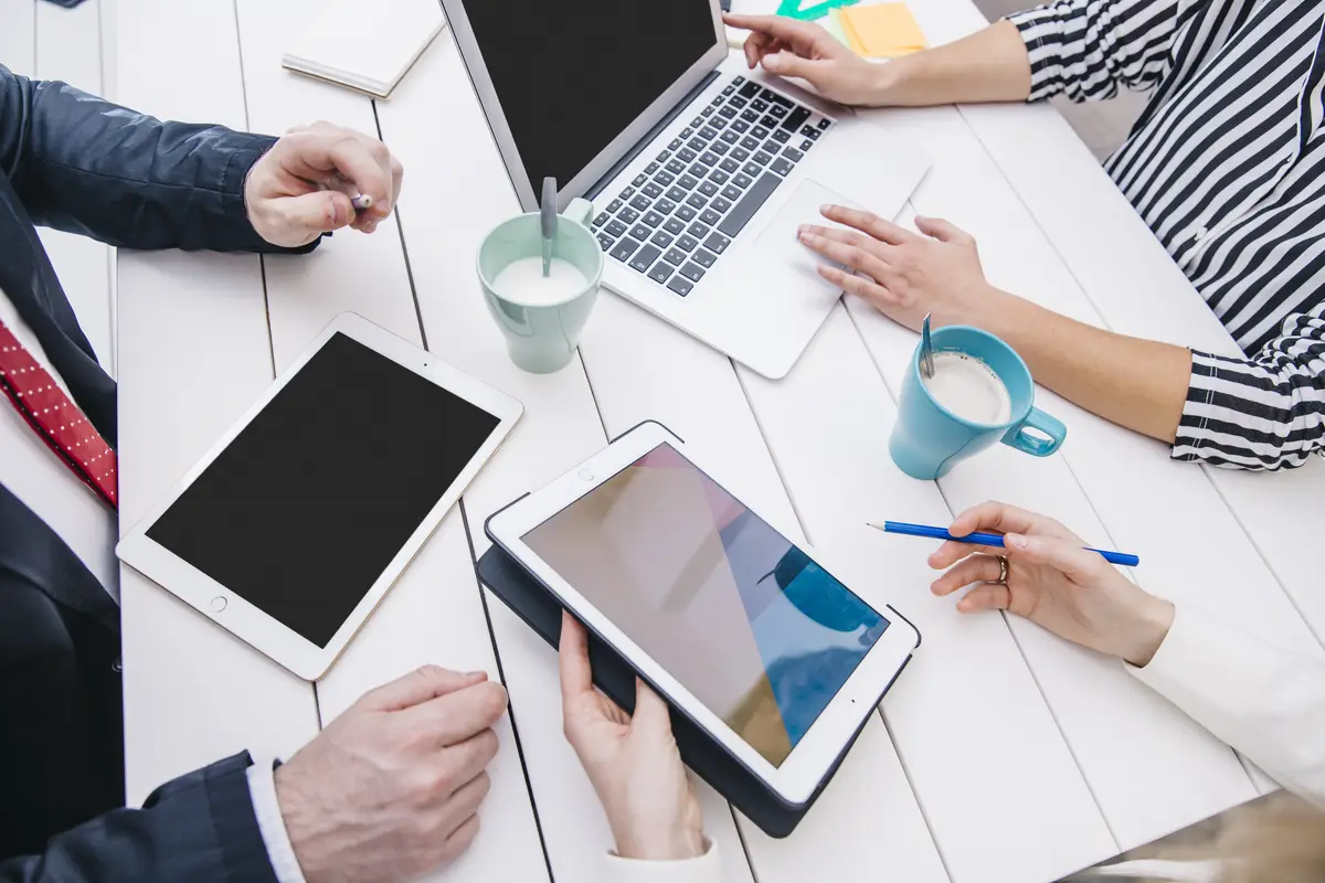 Businesspeople with devices at table