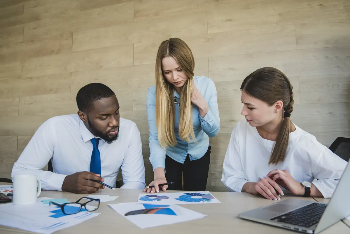 Two businesswomen and one businessman checking documents