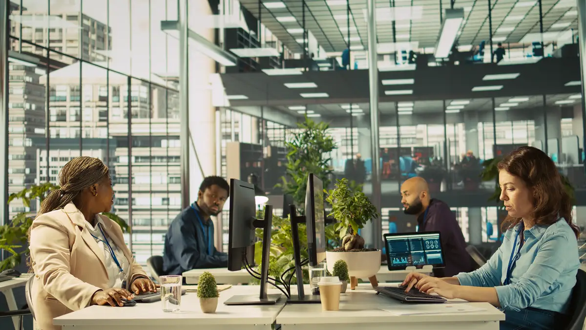 Accountant in busy modern startup agency imputing financial figures on PC