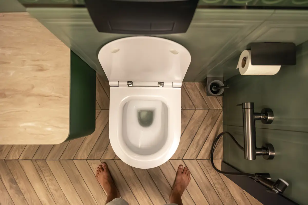 Redução da contaminação ambiental de pias e ralos em hospitais 3 Person in bathroom modern toilet top view minimalist interior